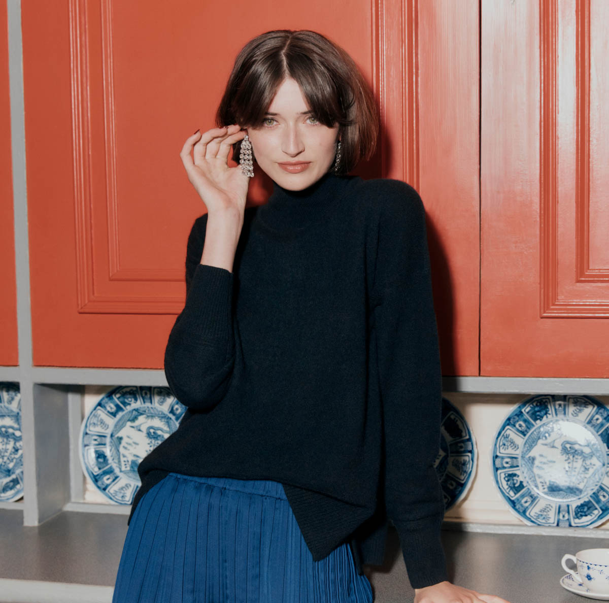 Image of a model in a kitchen wearing a cashmere jumper.