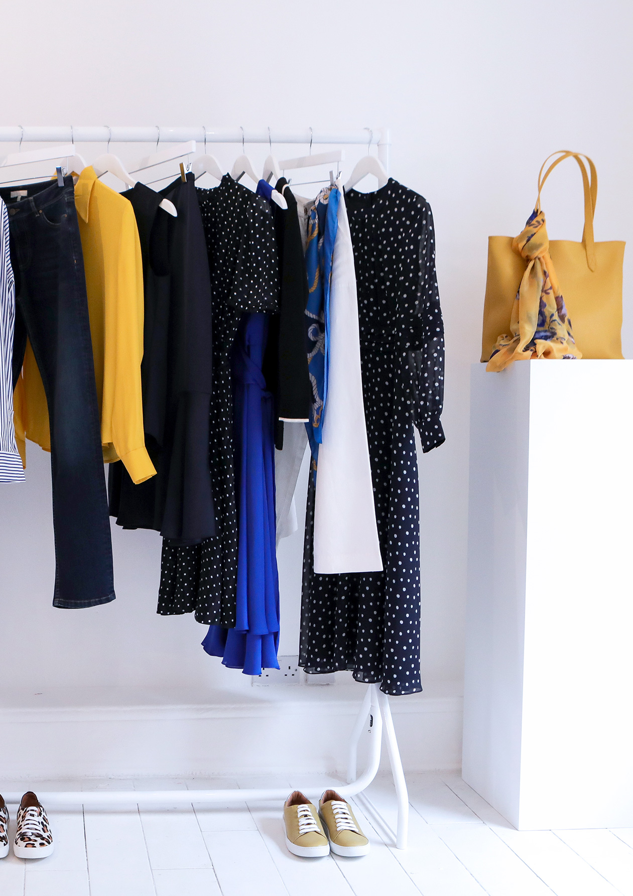 As the seasons change so does your wardrobe, a whiet clothes rail with a varity of navy blue, yellow and white clothes.