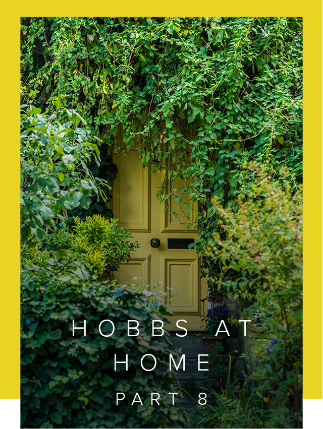 A yellow front door surronded by greenery