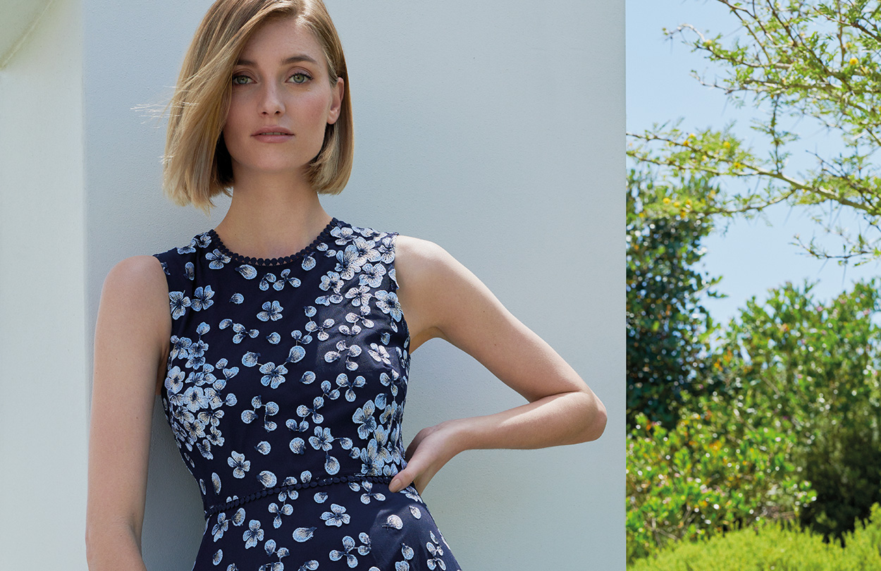 Blue floral dress paired with a blue wristlet clutch bag by Hobbs.