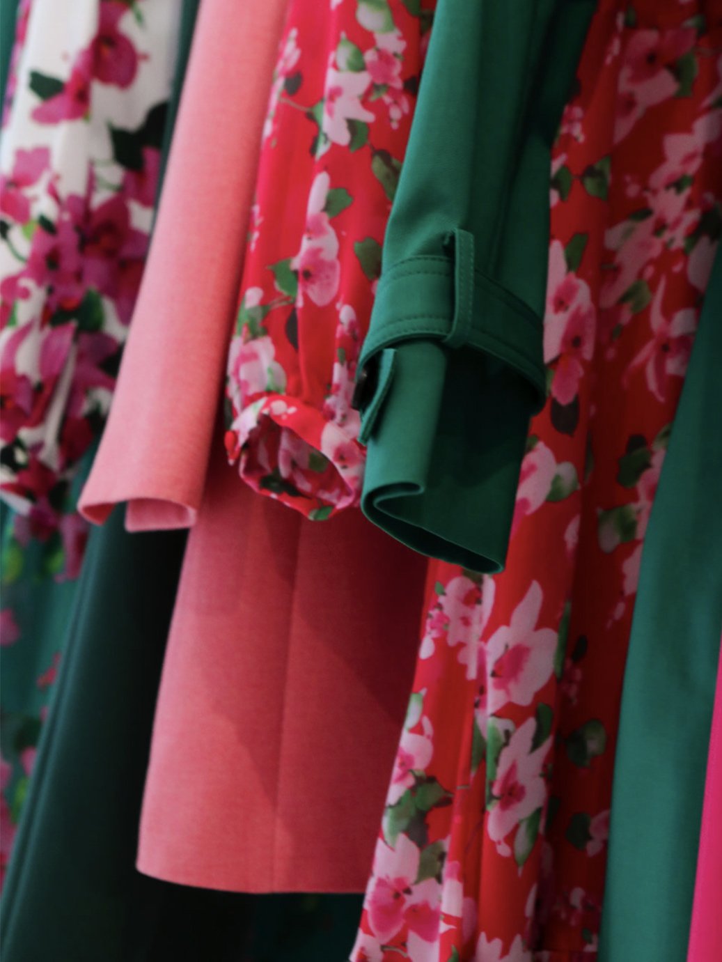 BlInterior image of wardobe featuring bright pink, green and floral clothing