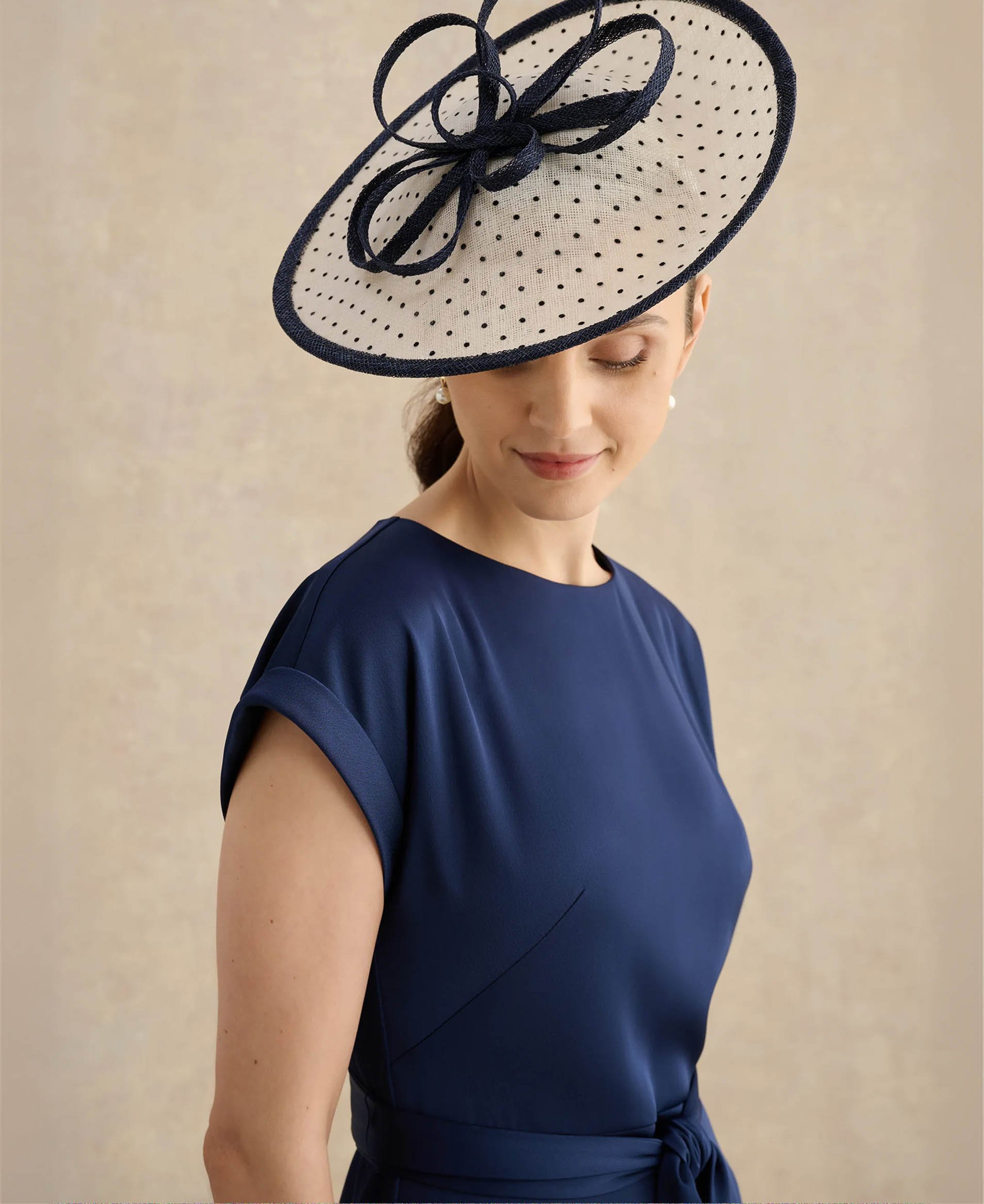 A woman wearing a polka dot fascinator.