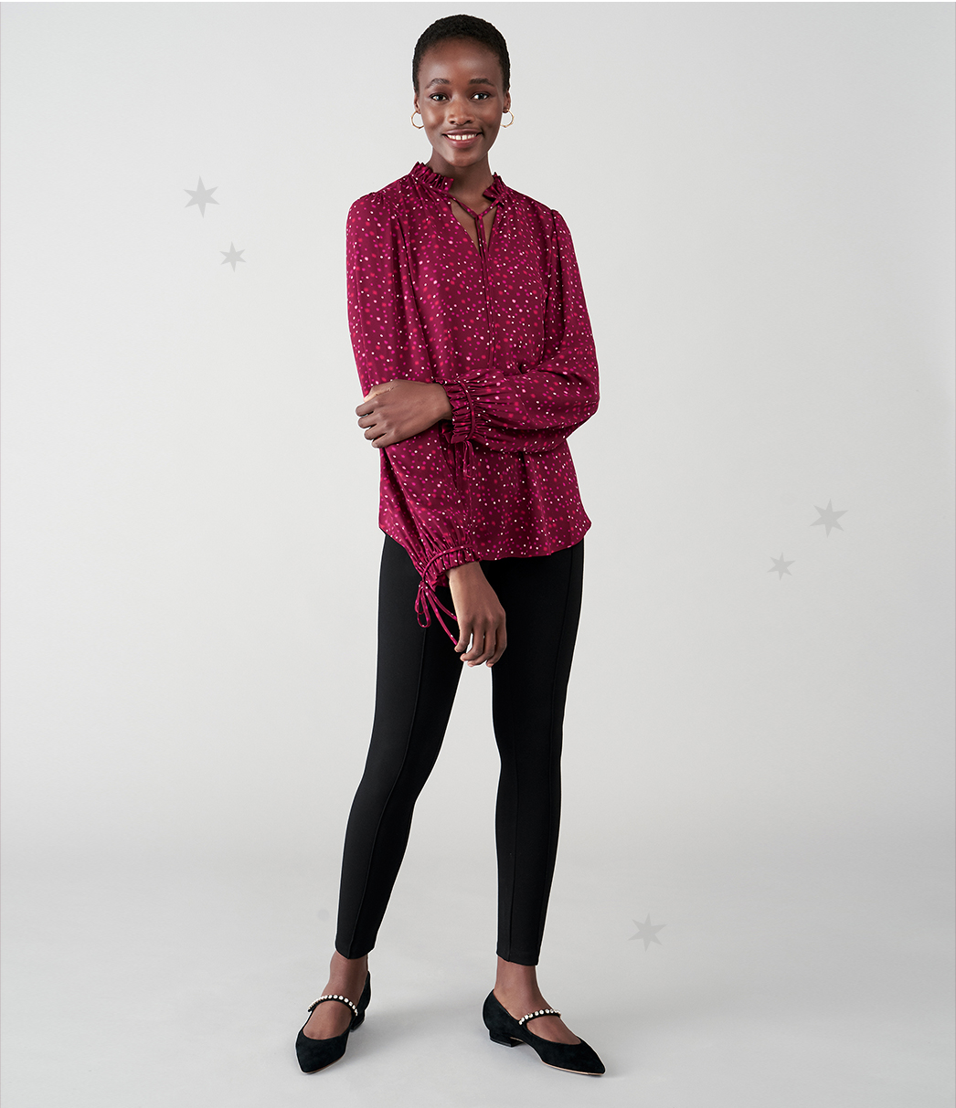 Model wears a star print blouse with leggings and embellished shoes.