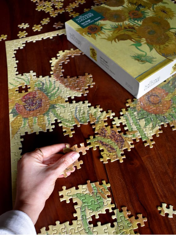 On the left, Jen works to complete her jigsaw. On the right is  an interior shot of Jen's home.