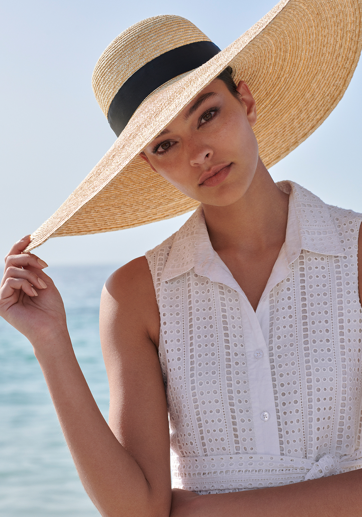 Key pieces needed for summer, include a wide brimmed straw hat with a black band with a white  cotton sundress 