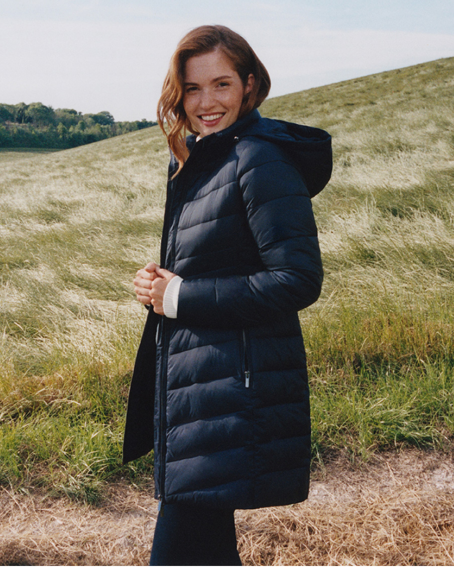 Model photographed leaning on a wall wearing a Hobbs navy checked coat.