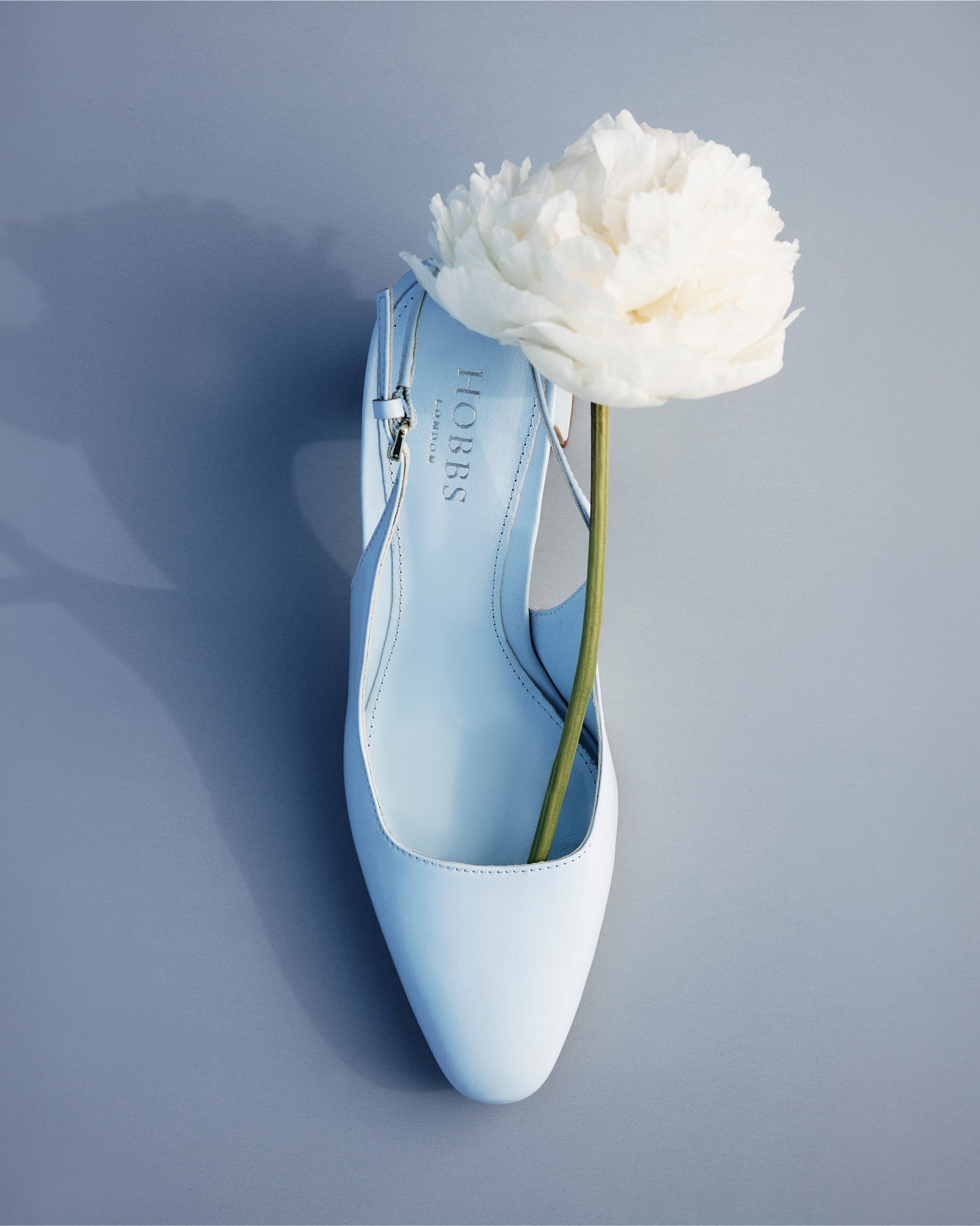 A gallery of two images of a pair of blue block heels by Hobbs.