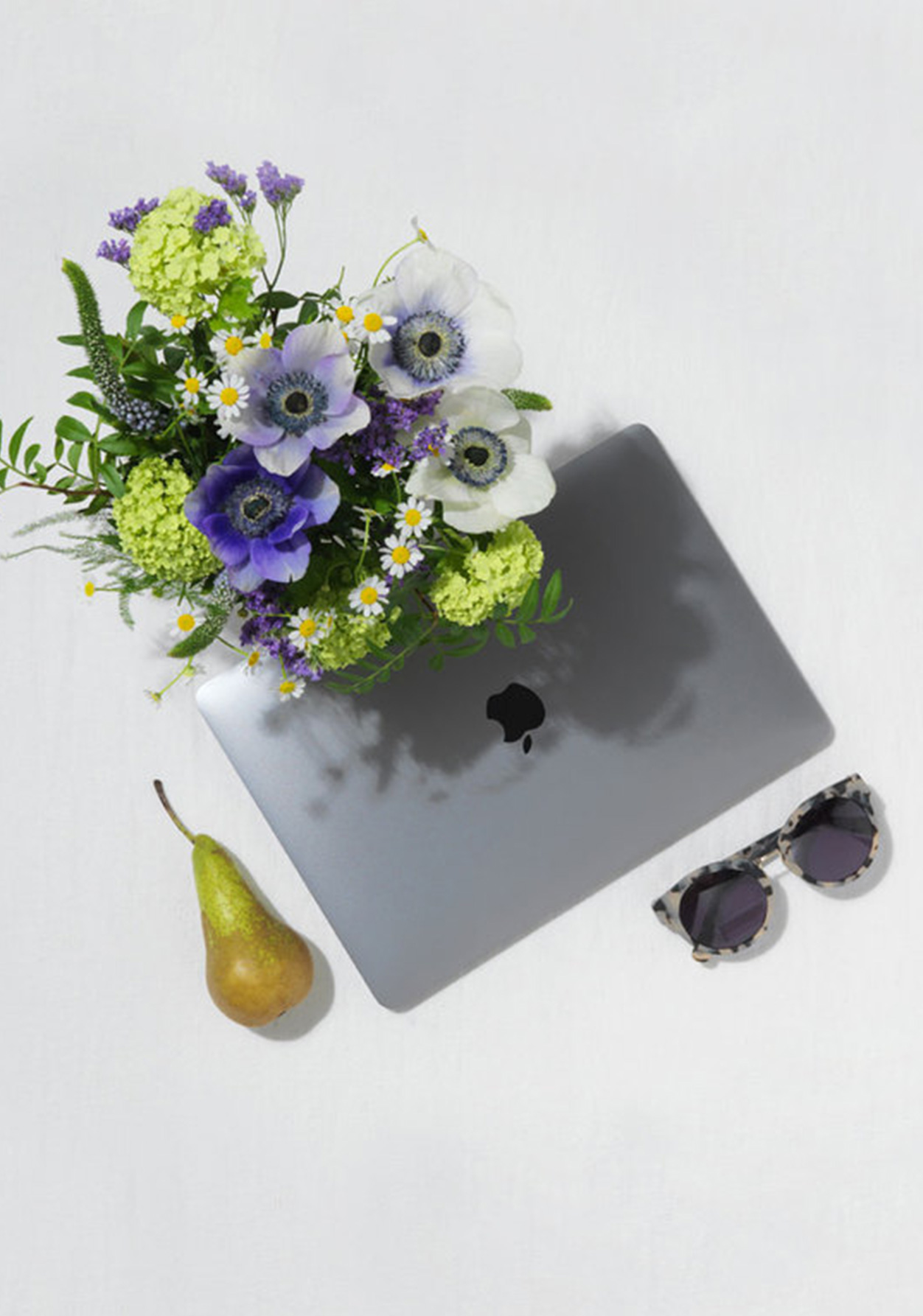 Flat Lay Of  A Laptop, Fuit, Flowers and Sunglasses