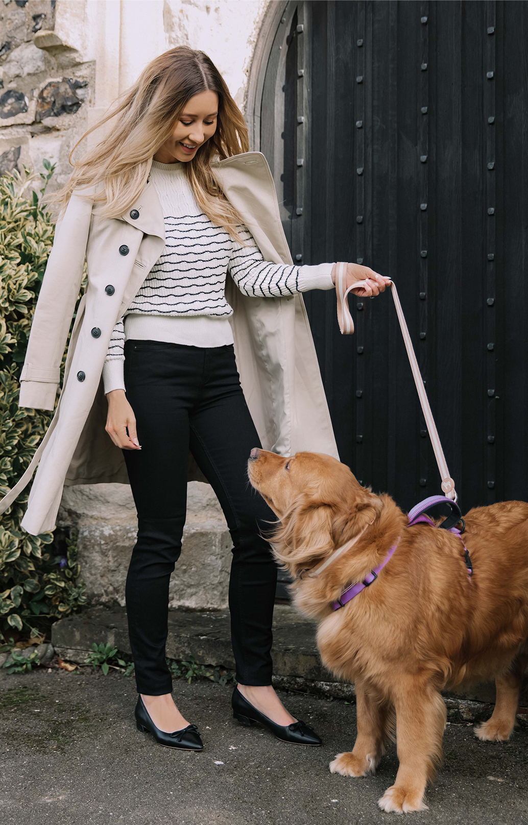 Fashion blogger @shegoeswear photographed on a walk wearing Hobbs Saskia neutral trench, Daniella jumper and Gia black jeans.