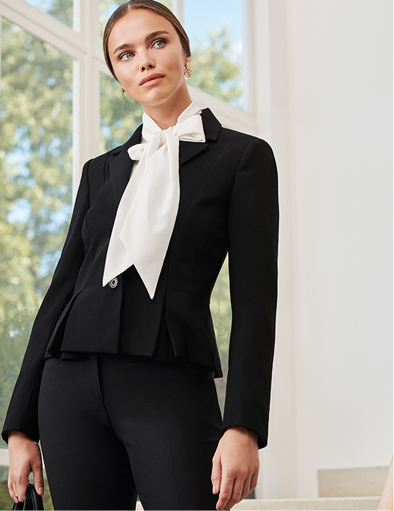 Model wears smart black suit and a white shirt