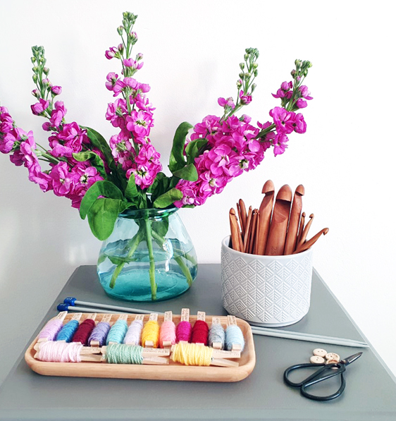 Hobbs Print Designer, Nicole Pope's corchet set at home accompanied by a purple floral arrangement