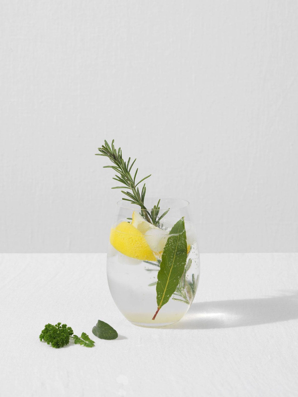 Glass containing refreshing Gin Fizz Cocktail with Lemon and Rosemary