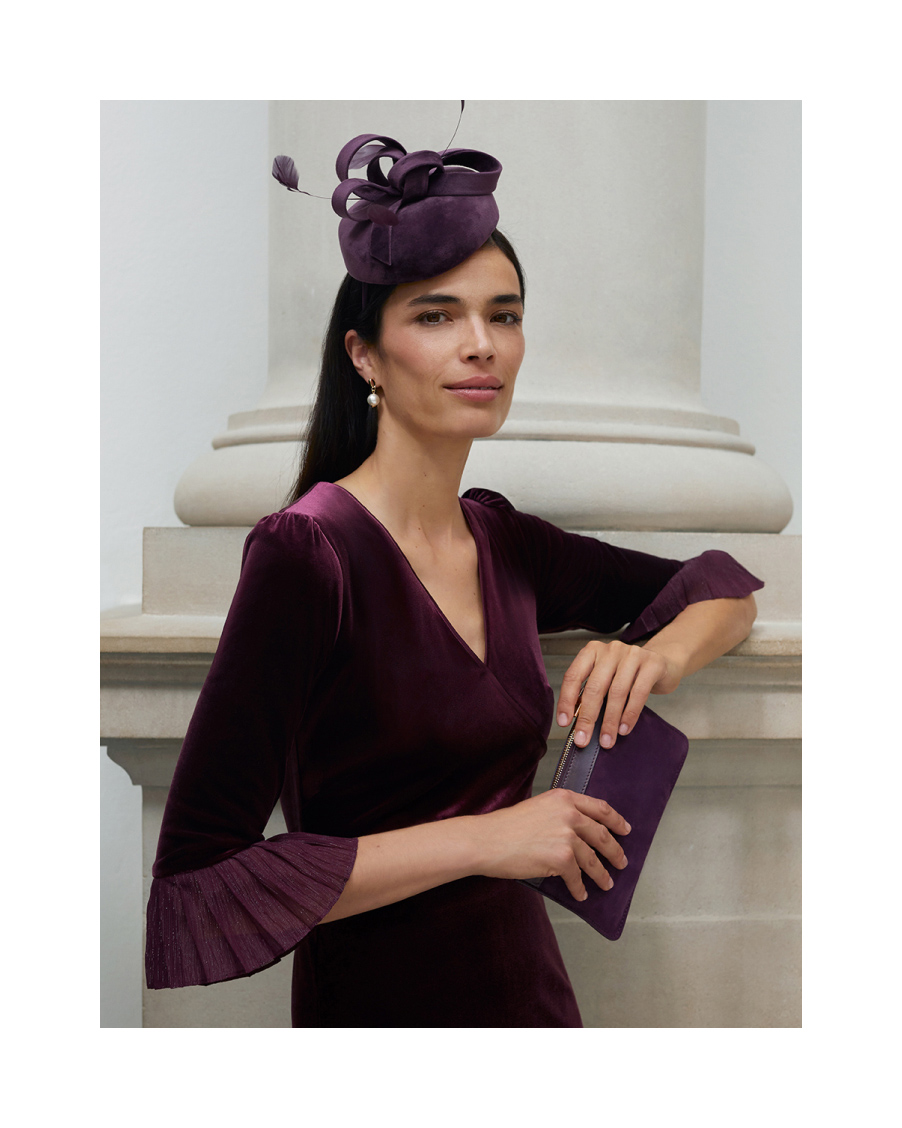 Hobbs model a velvet dress with matching fascinator and clutch bag.