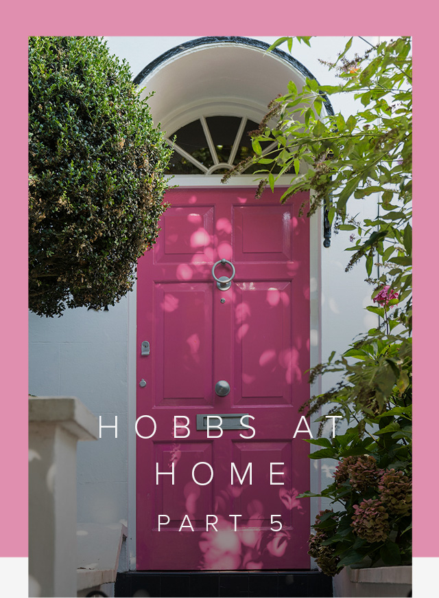 A classic hampstead townhouse frontage with a pink front door, with surrounding greenery.