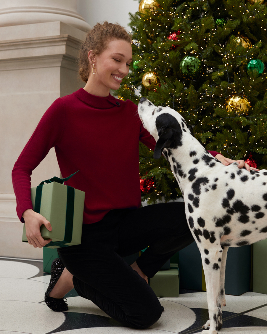 Hobbs model wears a festive red jumper, velvet jeans and sequin ballerina pumps.