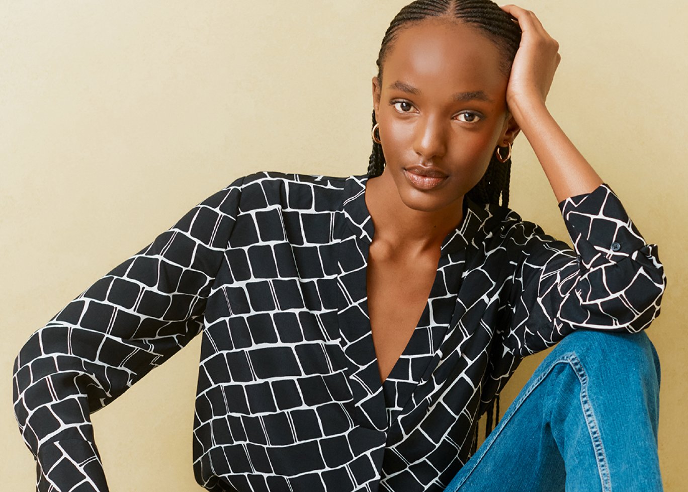Hobbs model wears a navy blue blouse with denim jeans