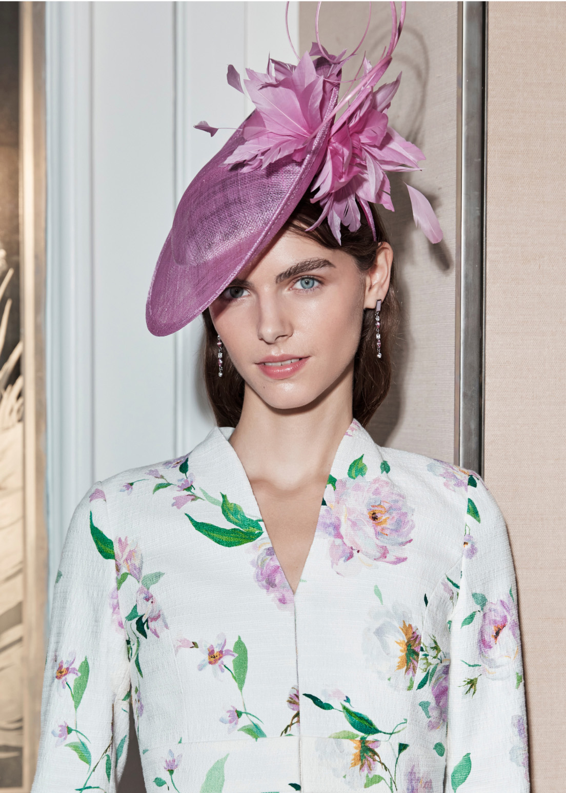 Image of model wearing a pink fascinator at a wedding.