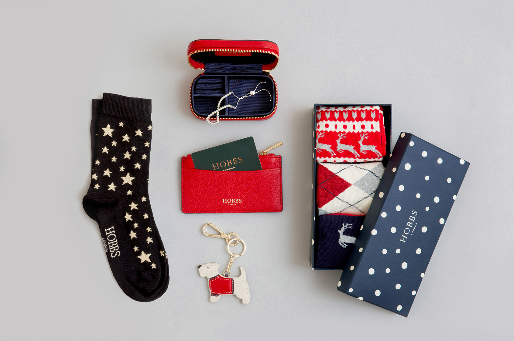 A selection of Christmas stocking fillers including a box of socks, keyring and leather cardholder.