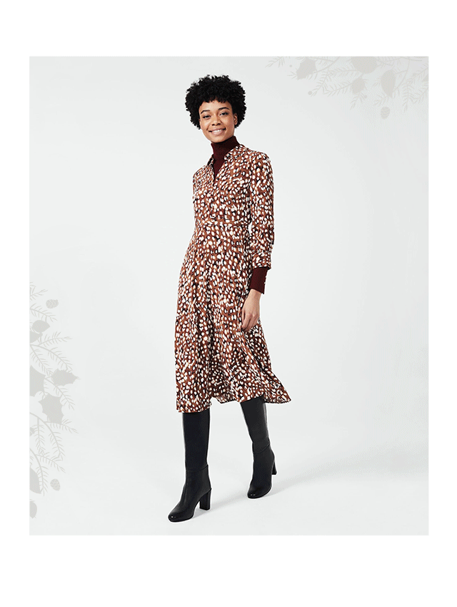 Model wears a Hobbs animal print shirt dress over a burgundy roll neck and black long boots.