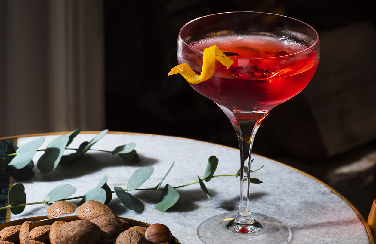 Image of a Christmas cocktail and bowl of nuts displayed on a coffee table.