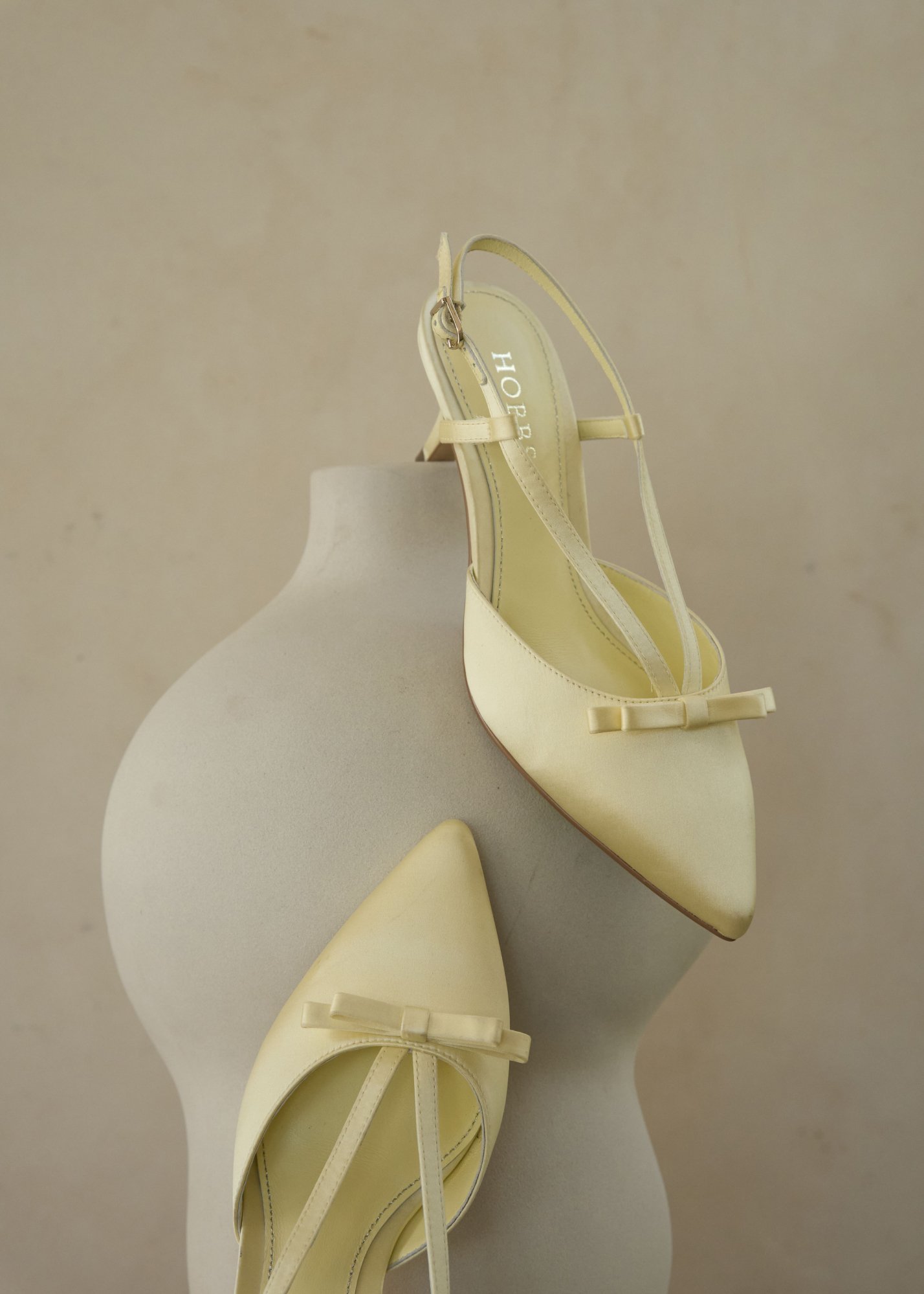 A buttermilk Hobbs satin bag and matching buttermilk Hobbs satin shoes.