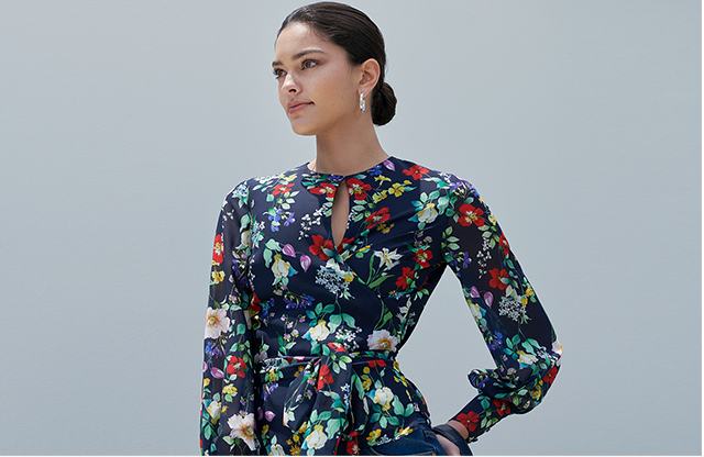 Model poses in the nevy blue floral wrap meadow blouse top