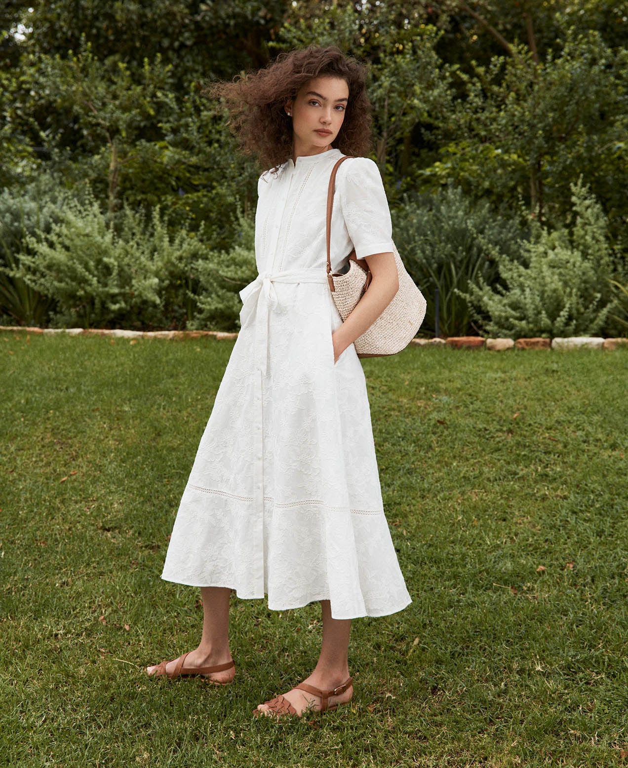 A woman wearing a Hobbs white summer dress.