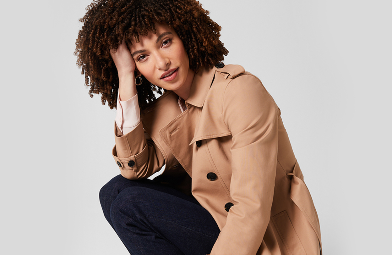 Model photographed in a crouched position wearing Hobbs camel Saskia trench.