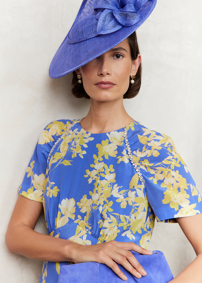 An image of a model wearing a Hobbs fascinator and occasion floral dress.