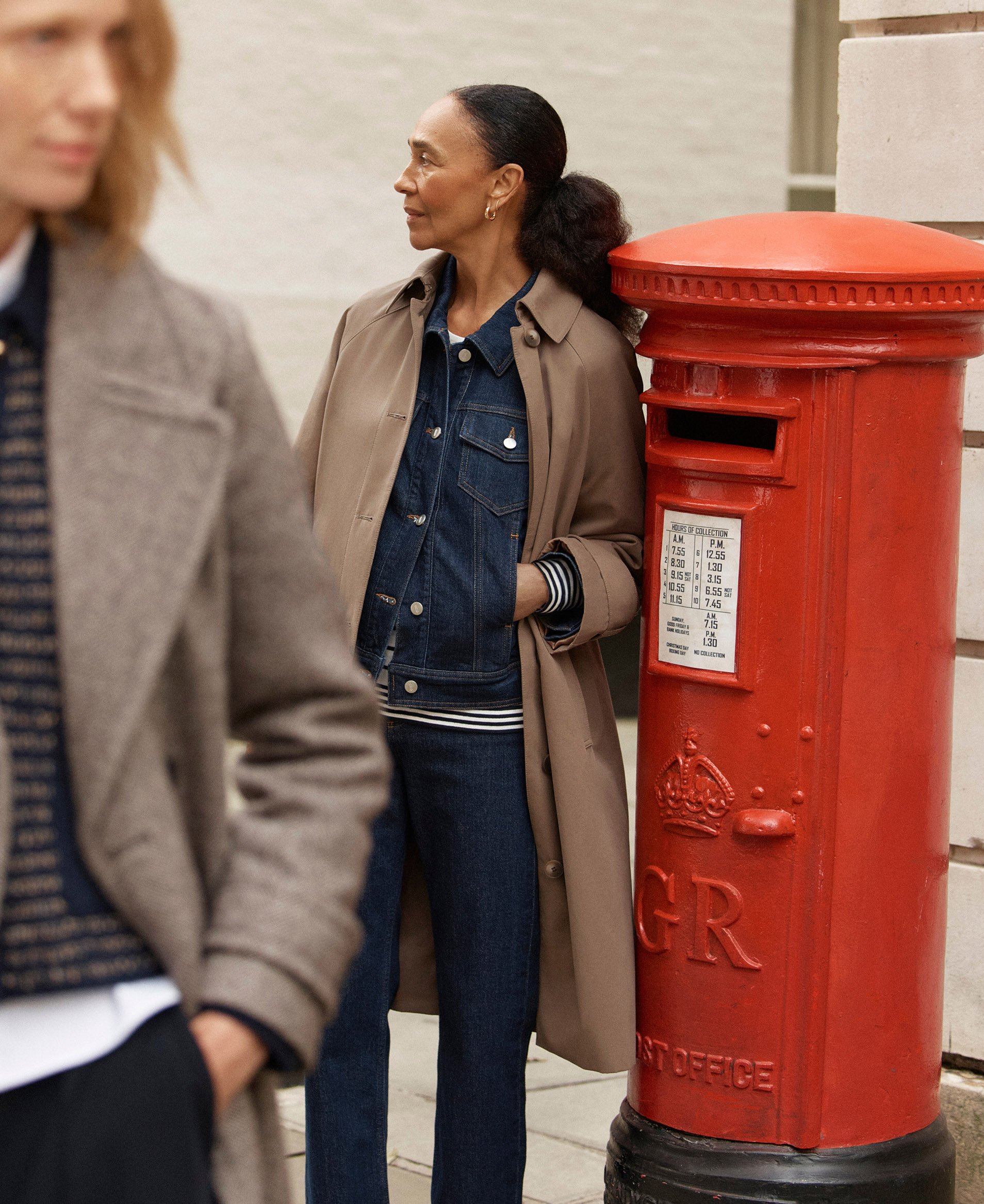 A woman wearing a mink trench over a denim co-ord.