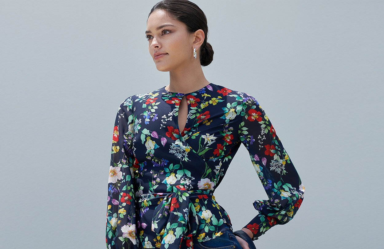 Model poses in the nevy blue floral wrap meadow blouse top