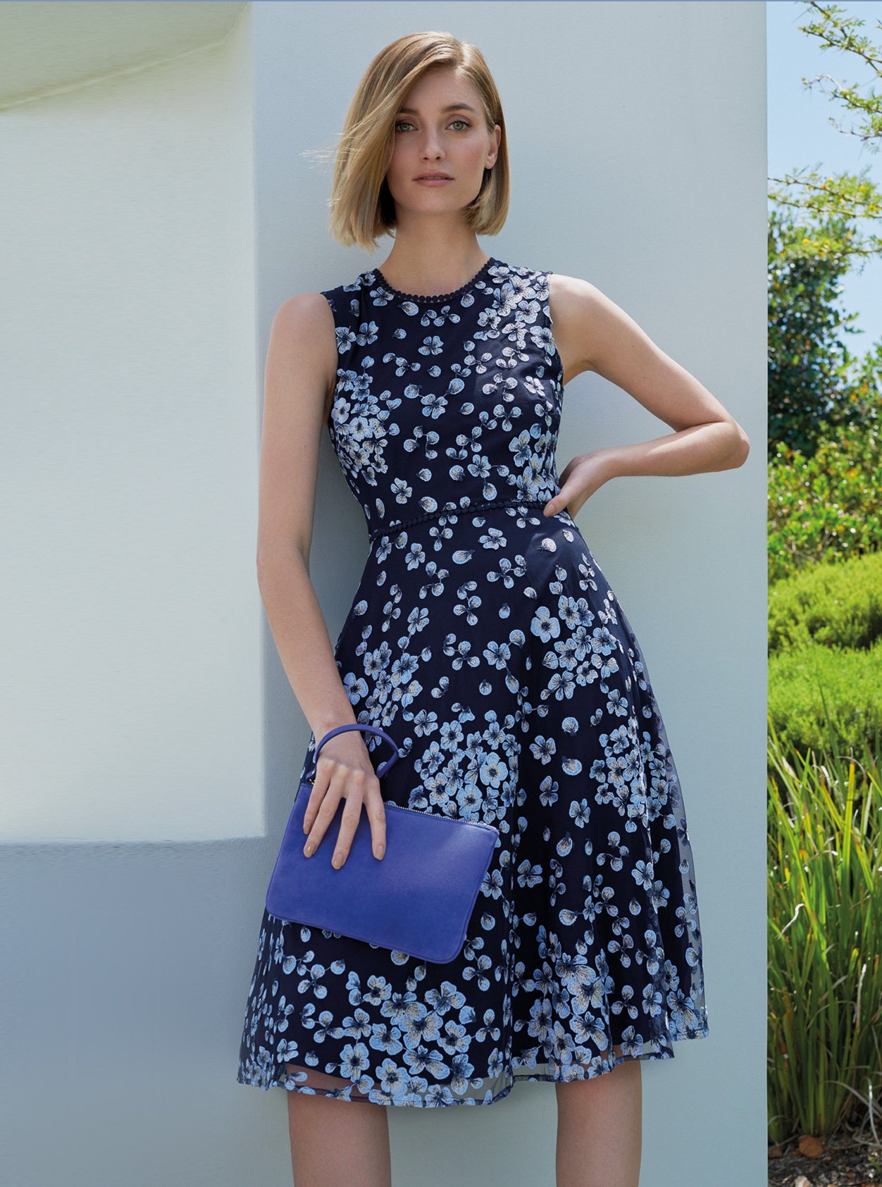 Floral fit and flare dress in blue with a matching blue wristlet clutch by Hobbs, an ideal outfit for a wedding guest.