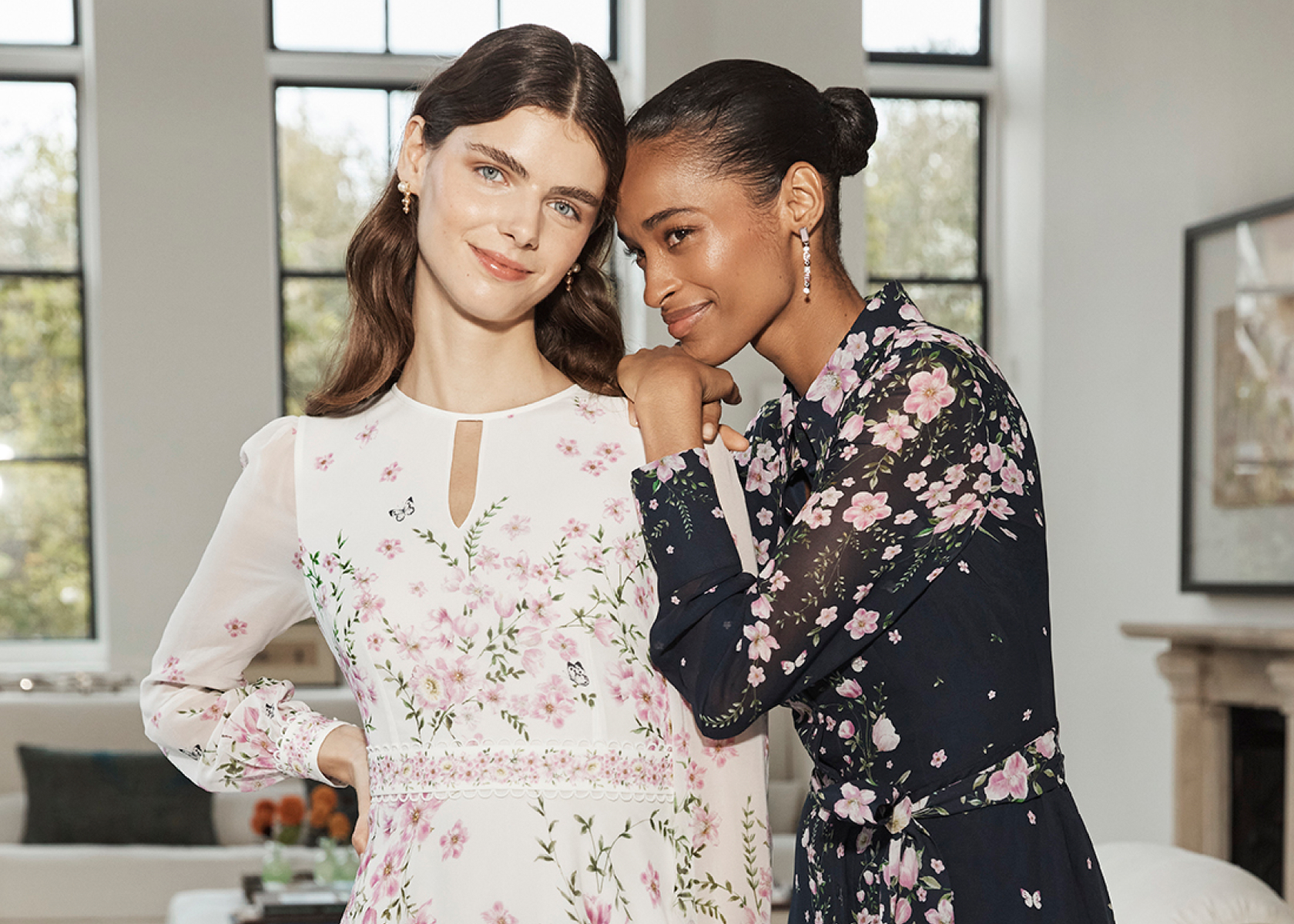 Hobbs models wearing floral print dresses and a blush pink dress.