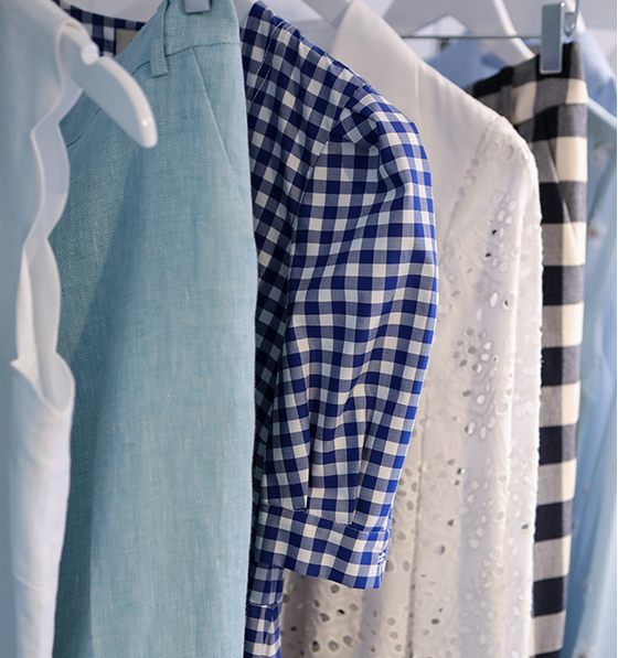 A stack of different shade of denim sit on a blue plinth