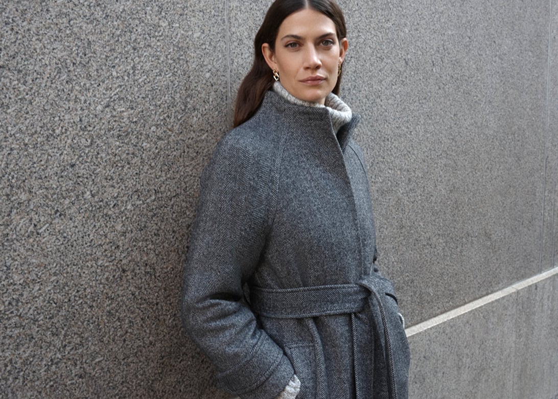 Model photographed in a grey coat.