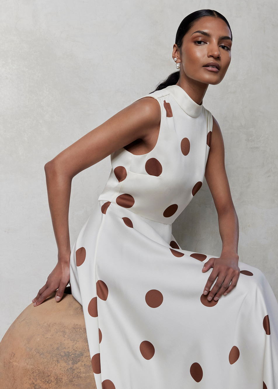 An image of a model wearing a polka dot ivory occasion dress.