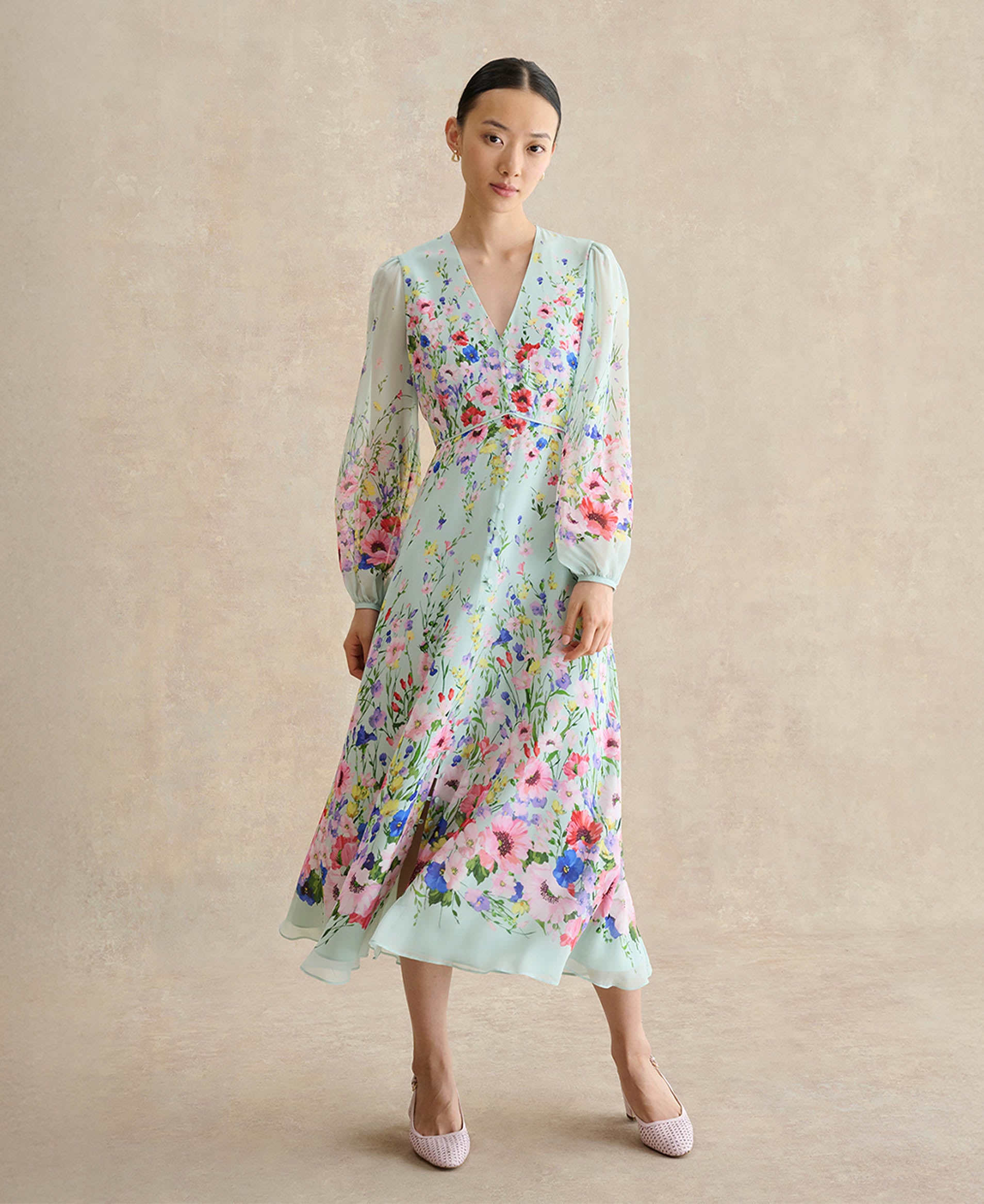 A woman wearing a sage green wedding guest dress.