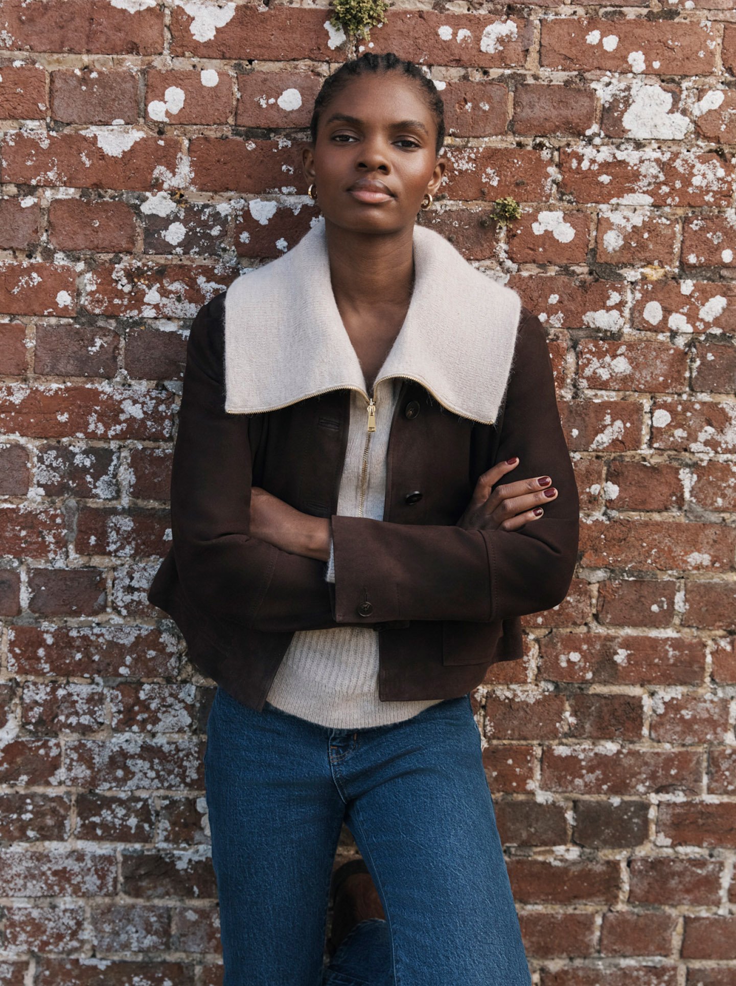 Woman wearing a brown suede jacket.