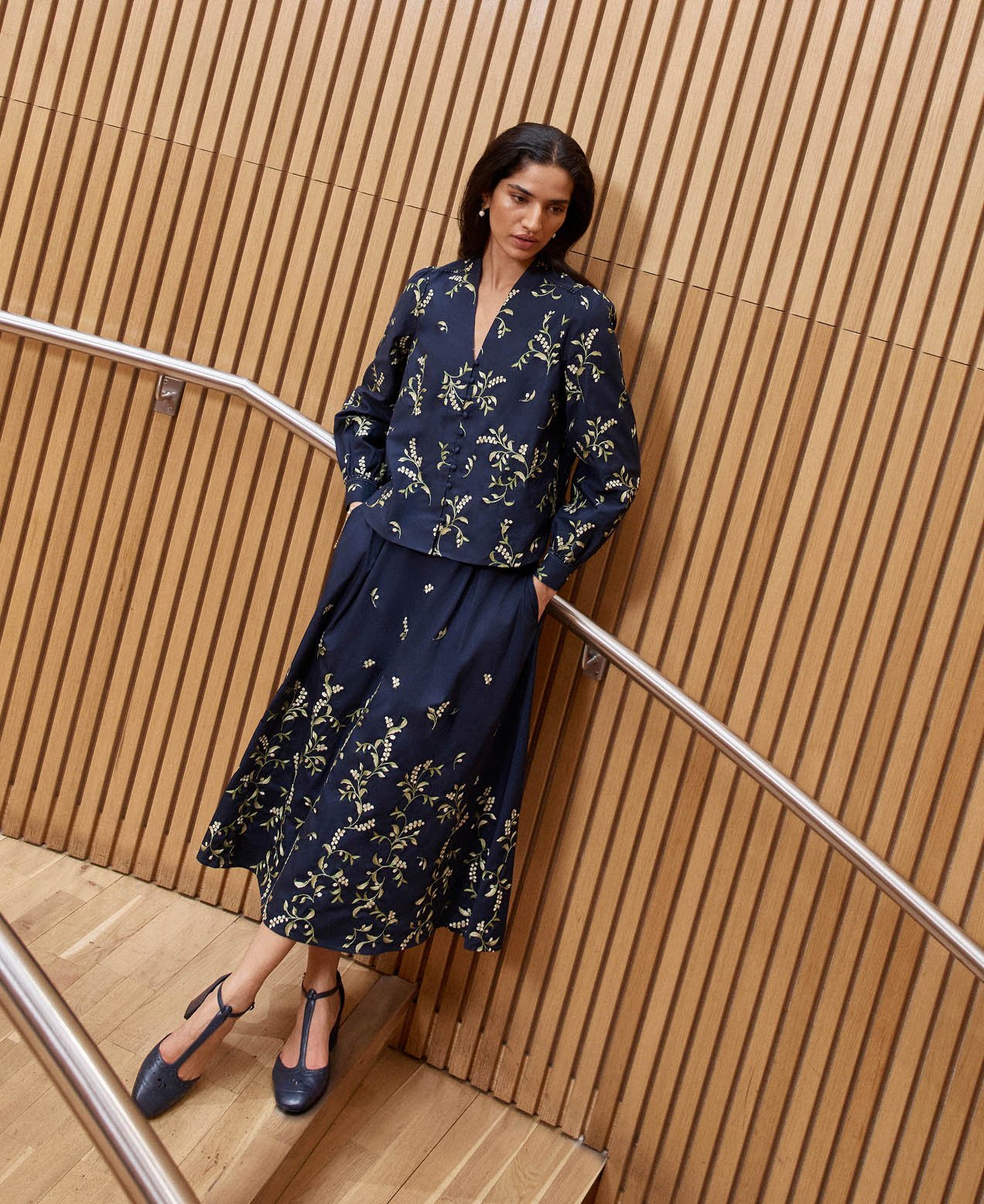 A woman wearing an embroidered navy two piece.