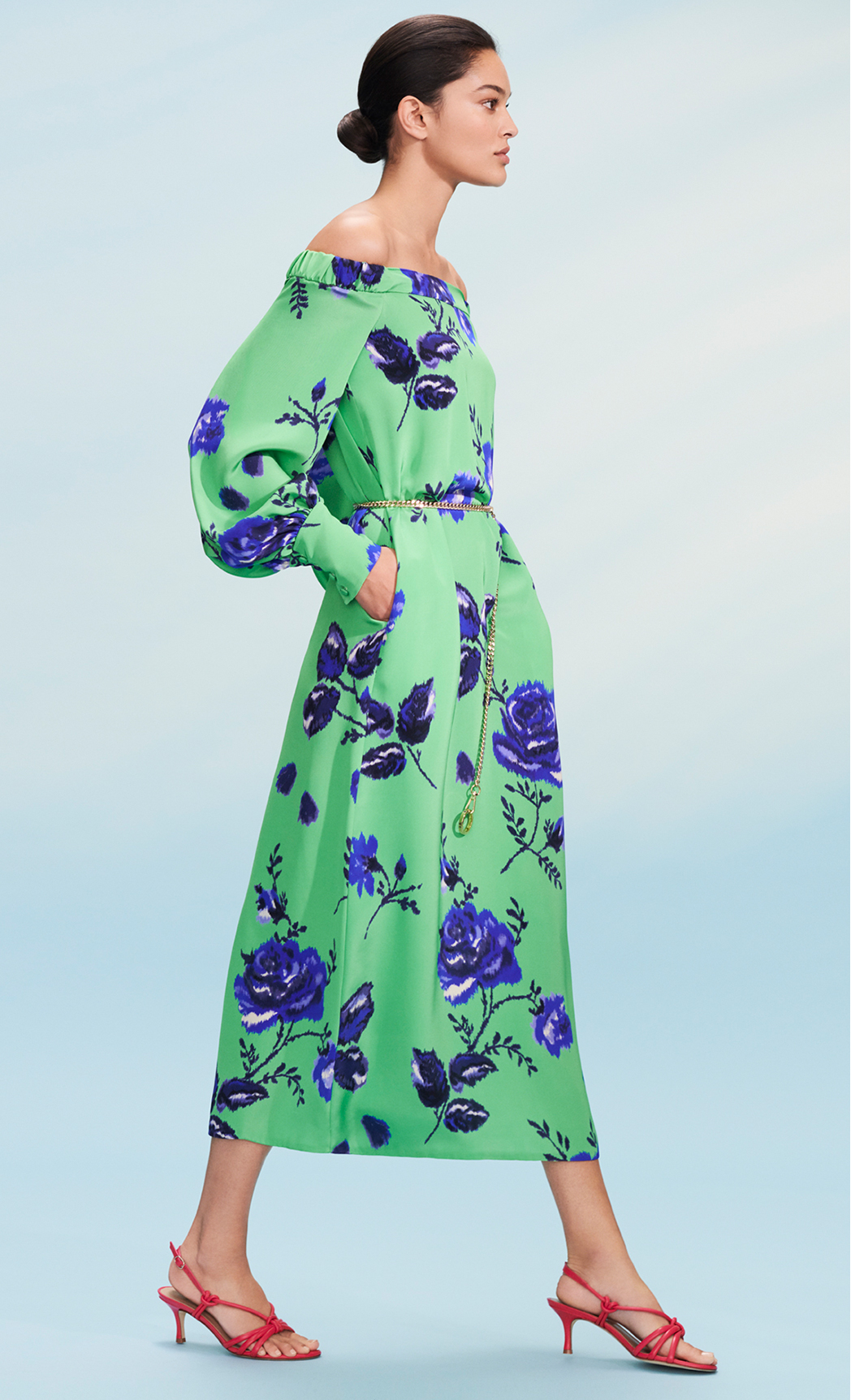 Model poses in a off the shoulder paradise green with cobalt blue floral print midi dress