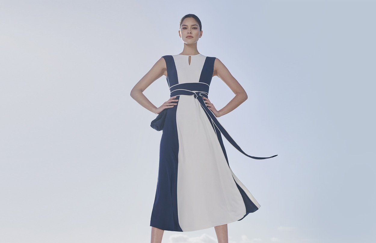 Fit and flare occasion dress in white and navy with a waist tie detail paired with espadrille sandals in navy, by Hobbs.