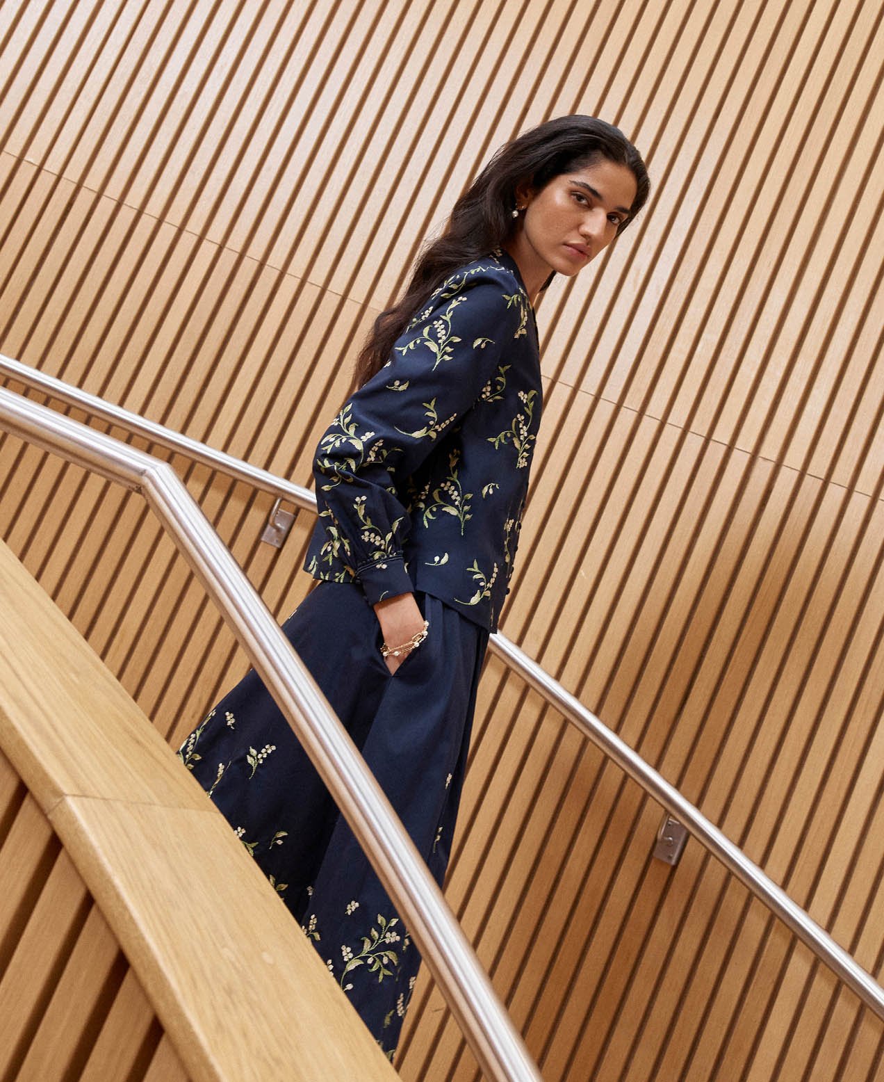 A woman wearing an embroidered navy two piece.