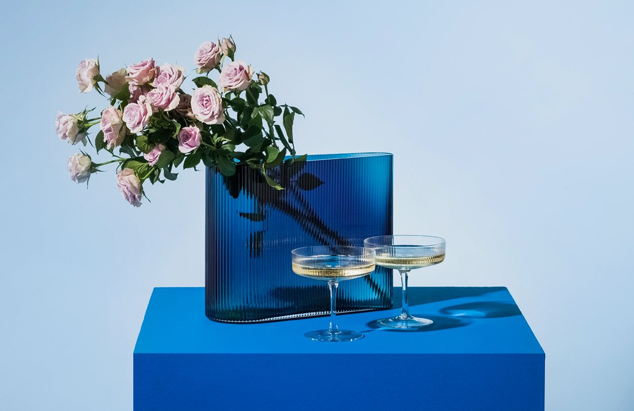 Spruce Up your fizz with two champagne coupes styles with a cobalt blye vase and dusky pale pink roses