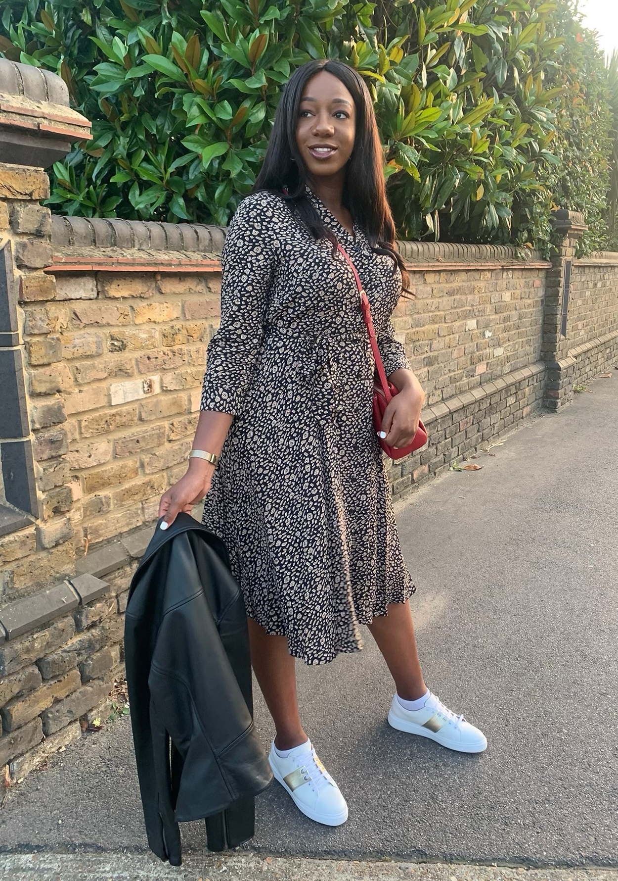 Hobbs Senior Digital Designer, jessica King wears the camel and navy rosaline midi dress with white trainers and a leather jacket 