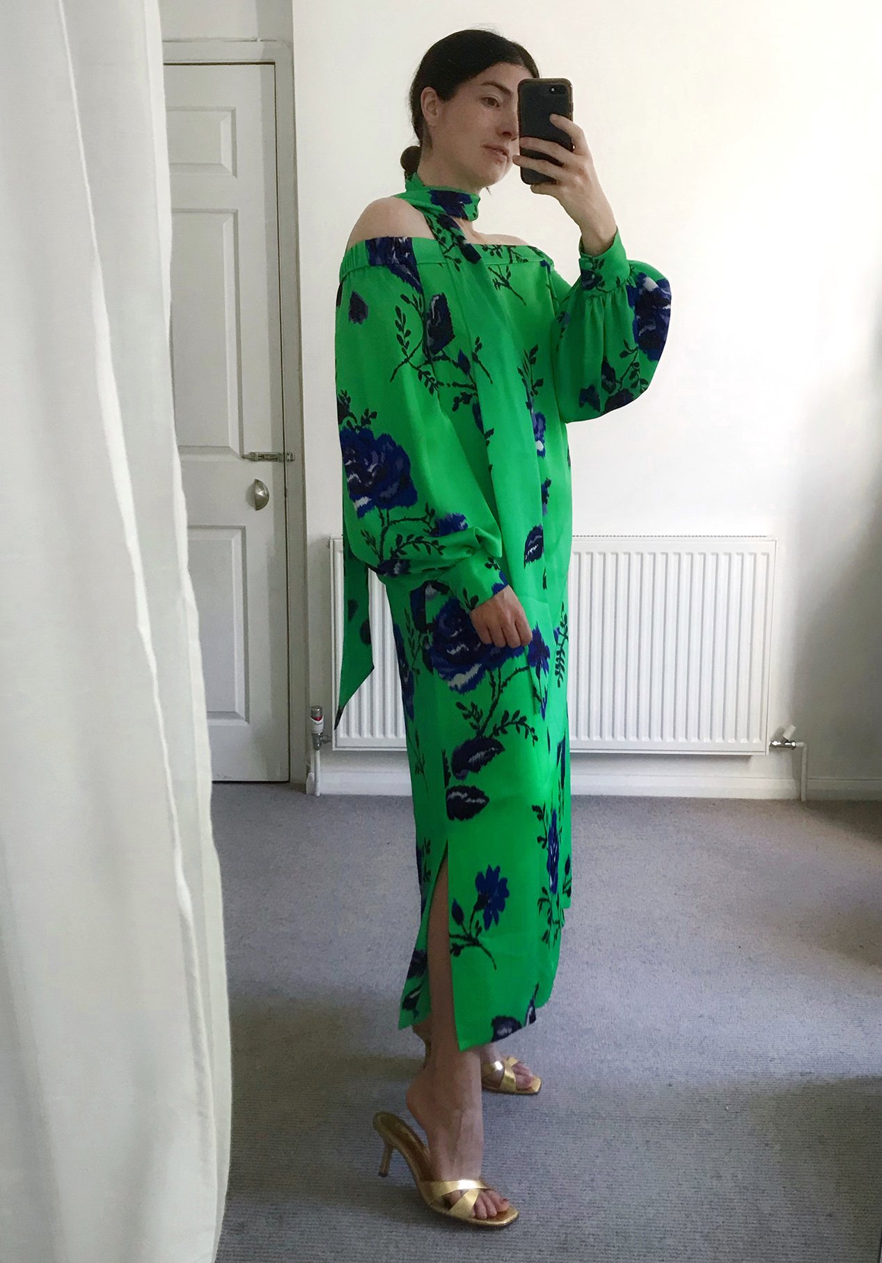 Women poses in a dark blue floral midi dress with bright red espadrille heeled shoes.