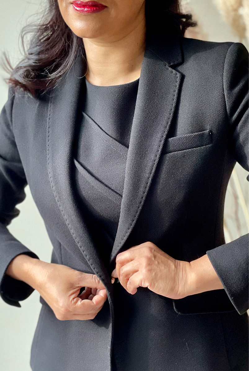 Close-up of fashion blogger Monika Mandal fastening Hobbs petite Ophelia black jacket.