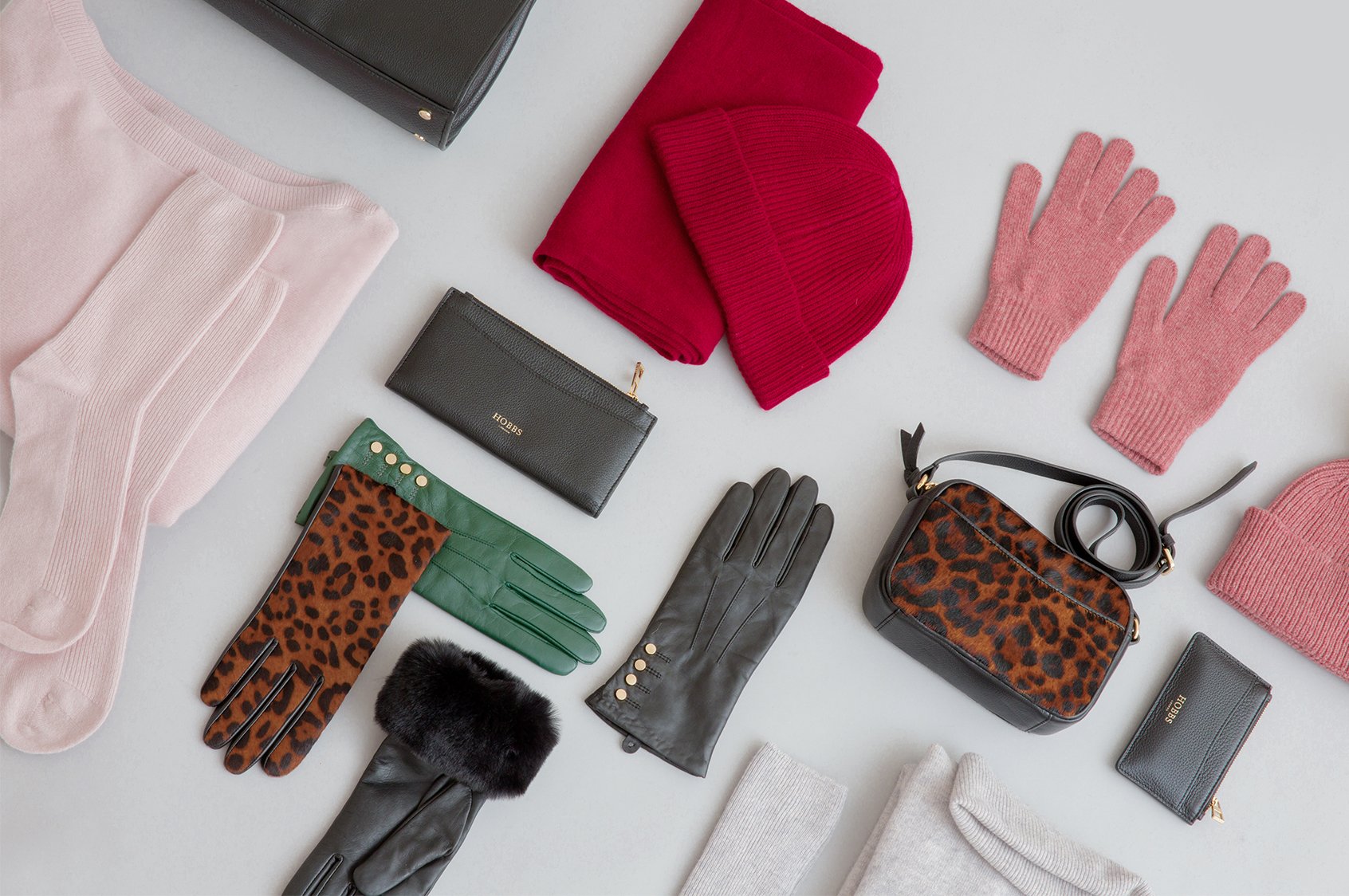 A selection of Christmas gifts including leather accessories and knitted hats, gloves and scarves.