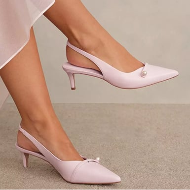 A woman wearing a blush pink occasion outfit.