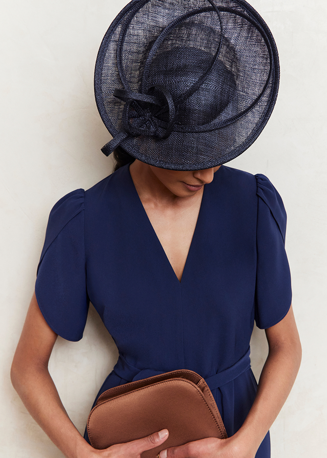 An image of a model wearing a Hobbs navy fascinator.