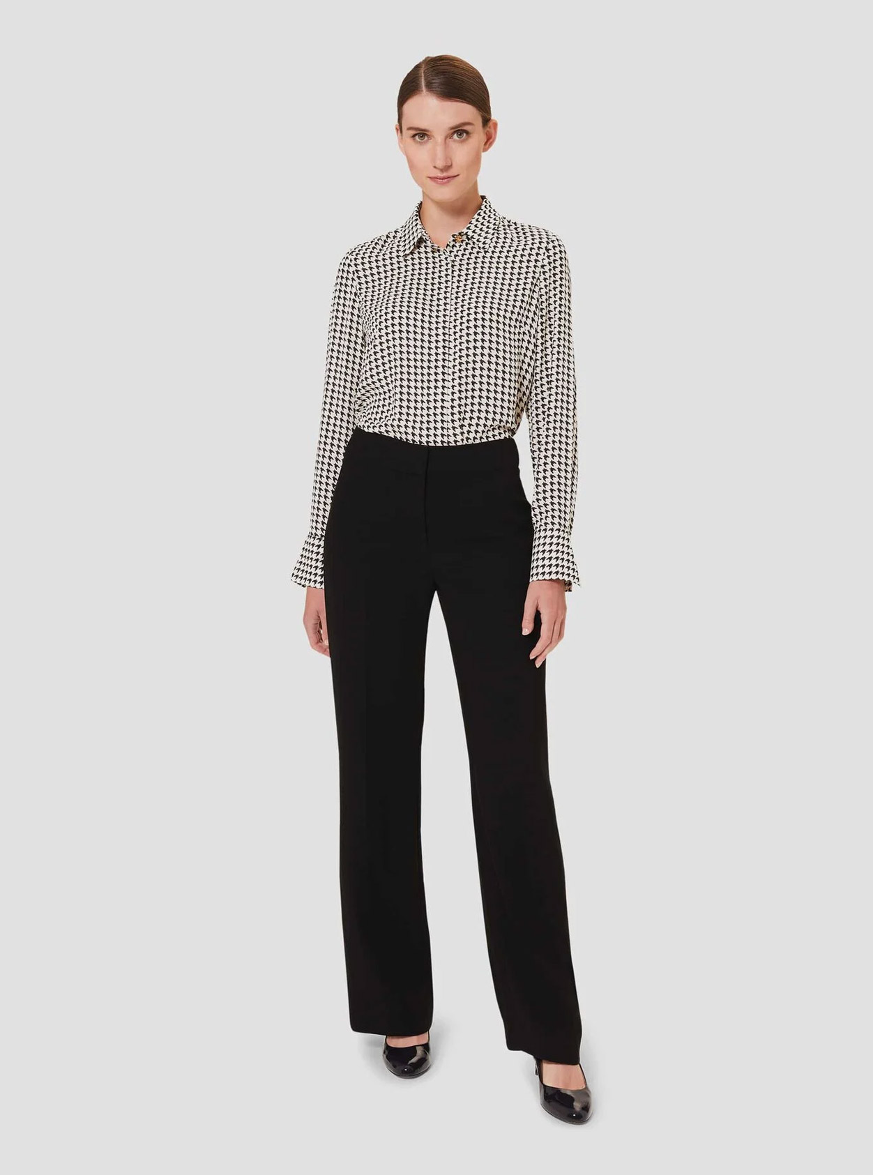  Long-sleeved work shirt with a dogtooth pattern paired with black wide leg trousers for women with black court shoes by Hobbs.